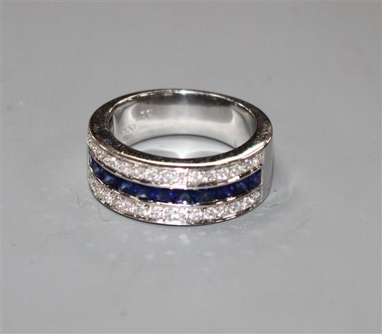 A modern 750 white metal sapphire and diamond set three row half eternity ring, size M, gross 9.2 grams.